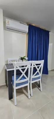a table and two chairs in a room with a blue curtain at Tiba Golden Oasis Royale Hurghada in Hurghada