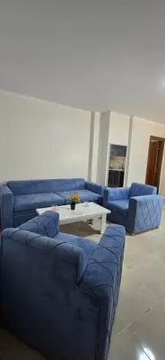 a living room with a blue couch and a table at Tiba Golden Oasis Royale Hurghada in Hurghada