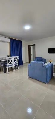a living room with two blue couches and a table at Tiba Golden Oasis Royale Hurghada in Hurghada