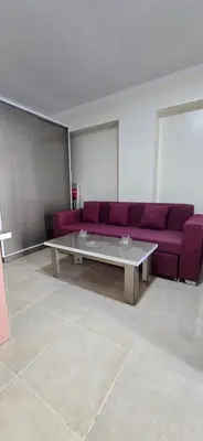 a living room with a purple couch and a table at Tiba Golden Blue Mirage Hurghada in Hurghada