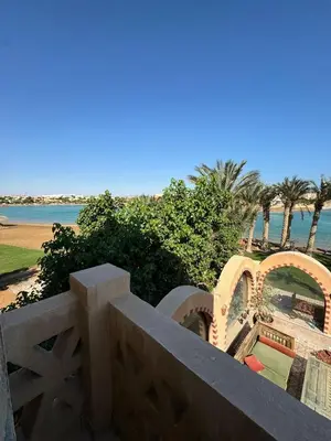 a balcony with a view of the beach and the ocean at El Gouna 4 Bedroom 4 Bathroom Lagoon villa in Banī Ghālib