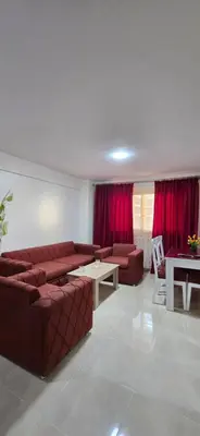 a living room with couches and a table and red curtains at Tiba Golden Sea Beiss Hurghada in Hurghada