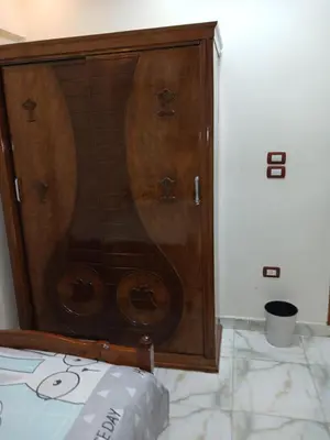 a wooden cabinet in a room with a bed at شقه فاخره مجهزه بالكامل مكيفه مع ثلاث غرف في وسط الاقصر in Luxor