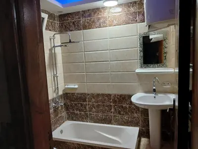 a bathroom with a sink and a tub and a toilet at شقه فاخره مجهزه بالكامل مكيفه مع ثلاث غرف في وسط الاقصر in Luxor