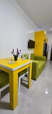 a living room with a yellow table and a green couch at Tiba Golden Oasis Mirage Hurghada in Hurghada