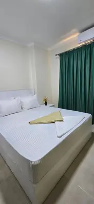 a bedroom with a large bed with a green curtain at Tiba Golden Oasis Mirage Hurghada in Hurghada