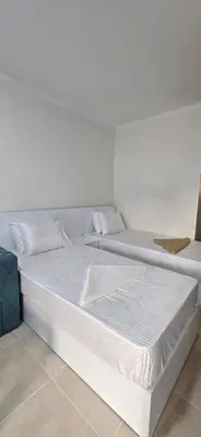 two beds in a room with white walls at Tiba Golden Crystal Lagoon Hurghada in Hurghada