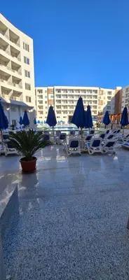 a group of lounge chairs and umbrellas on a beach at Tiba Golden Crystal Lagoon Hurghada in Hurghada