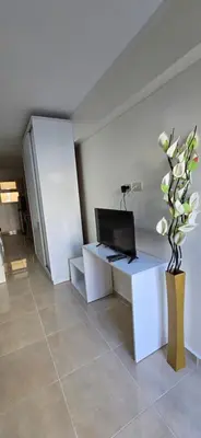 a living room with a tv and a vase of flowers at Tiba Golden Crystal Lagoon Hurghada in Hurghada