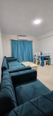 a room with four blue beds and a table at Tiba Golden Sun flare Hurghada in Hurghada