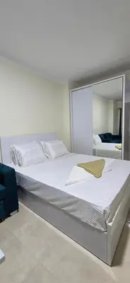 a bedroom with a large white bed with a mirror at Tiba Golden Azure Coast Hurghada in Hurghada