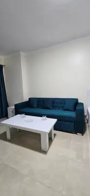 a living room with a blue couch and a white table at Tiba Golden Azure Coast Hurghada in Hurghada