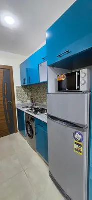 a kitchen with blue cabinets and a refrigerator at Tiba Golden Azure Coast Hurghada in Hurghada