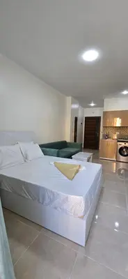 a bedroom with a white bed and a kitchen at Tiba Golden Aqua Vista Hurghada in Hurghada