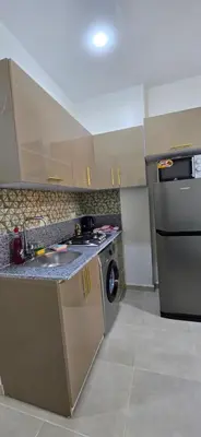 a kitchen with a stove and a washing machine at Tiba Golden Aqua Vista Hurghada in Hurghada