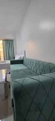 a living room with a green couch and a table at Tiba Golden Aqua Vista Hurghada in Hurghada