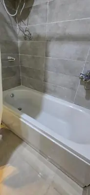 a white bath tub in a bathroom with a shower at Tiba Golden Sunset Oasis Hurghada in Hurghada