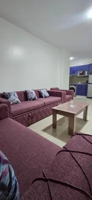 a living room with purple couches and a coffee table at Tiba Golden Beach View Hurghada in Hurghada