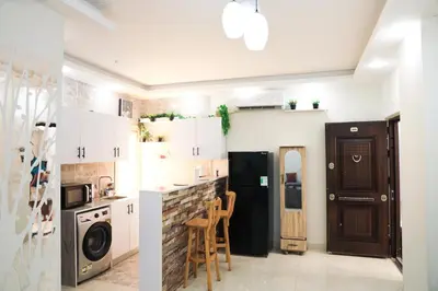 a kitchen with white cabinets and a stove top oven at Golden Home Hurghada El Kauser in Hurghada