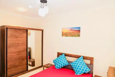 a bedroom with a red bed with blue pillows at Golden Home Hurghada El Kauser in Hurghada