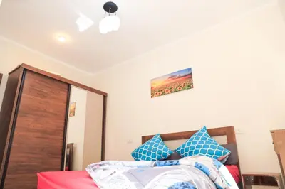 a bedroom with a bed with blue pillows at Golden Home Hurghada El Kauser in Hurghada