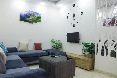 a living room with a blue couch and a tv at Golden Home Hurghada El Kauser in Hurghada
