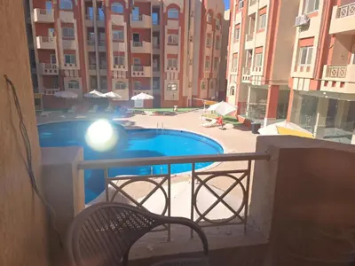 a balcony with a chair and a swimming pool at شقة in Hurghada