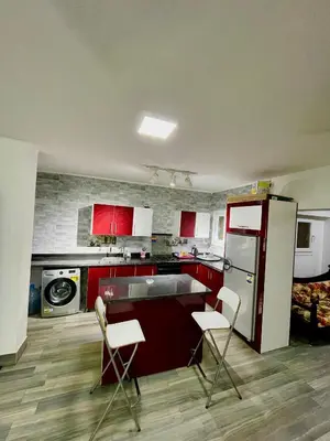 a kitchen with red cabinets and white appliances at El Hambra compound in Hurghada