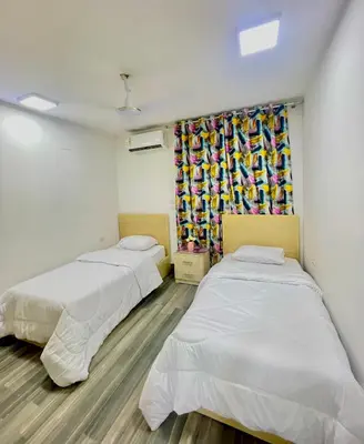 two beds in a room with a window at El Hambra compound in Hurghada