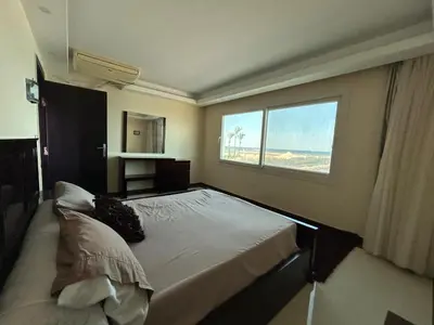a bedroom with a large bed and a window at Sea view chalet in Sahl Hasheesh