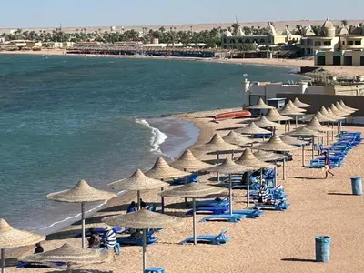 a group of umbrellas and chairs on a beach at Sea view chalet in Sahl Hasheesh