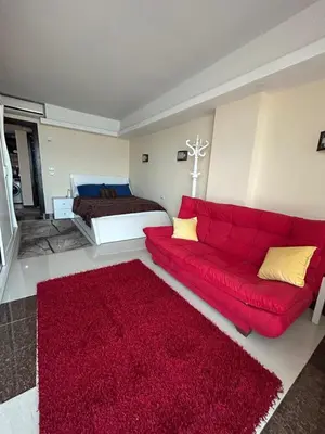 a living room with a red couch and a red rug at Sea view chalet in Sahl Hasheesh