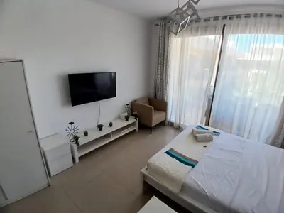 a white room with a bed and a television at Cozy Studio in Hurghada