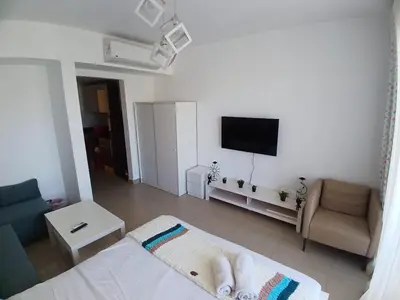 a white room with a bed and a tv at Cozy Studio in Hurghada