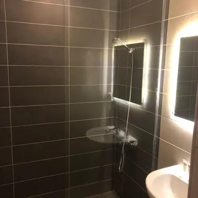 a bathroom with a shower with a sink and a mirror at Cozy Studio in Hurghada