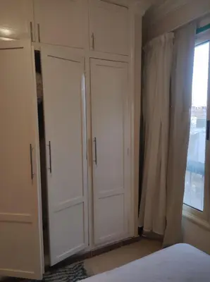 a bedroom with white cabinets and a window at Hurghada in Hurghada