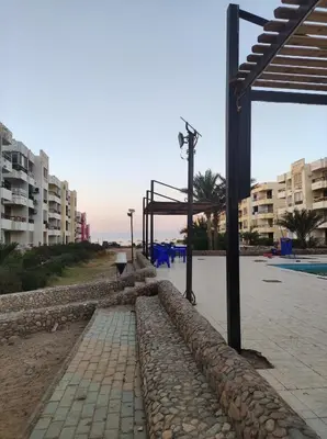 a walkway next to a pool with some buildings at Hurghada in Hurghada