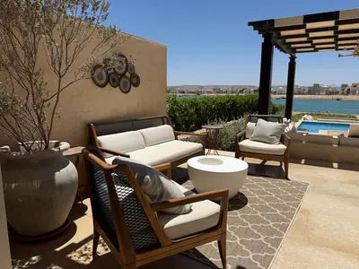 a patio with chairs and a table and a pool at Gouna's Best Villa in Hurghada
