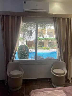 a bedroom with a window with a view of a pool at apartment for rent in hurghada in Hurghada