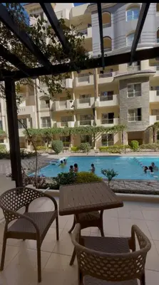 a patio with a table and chairs and a swimming pool at apartment for rent in hurghada in Hurghada