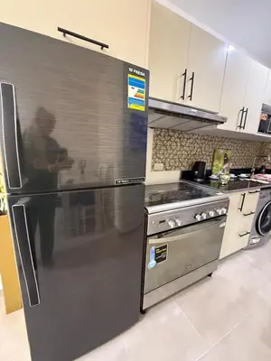 a kitchen with a stainless steel refrigerator and a stove at TiBa Golden Resort in Hurghada