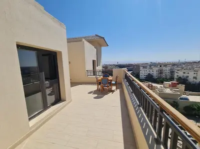 a balcony of a house with a table and chairs at AlDau Heights Modern Studio with Terrace, Mountain & City View in Hurghada