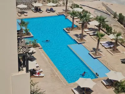 an overhead view of a swimming pool at a resort at AlDau Heights Modern Studio with Terrace, Mountain & City View in Hurghada