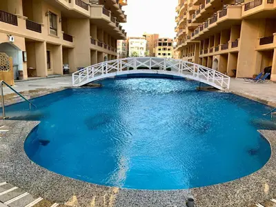 a large pool of blue water with a white bridge at Turtles Beach Resort - Hurghada in Hurghada