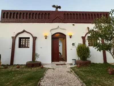 a white house with a door and a yard at Salem & Renča Guest House in Luxor