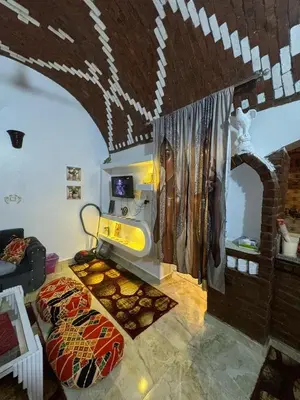 a living room with a bed and a table in a room at Salem & Renča Guest House in Luxor