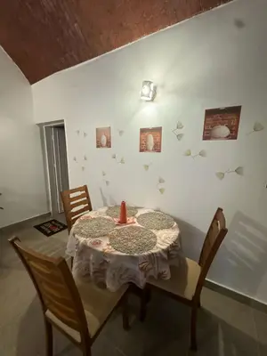 a dining room with a table with a vase on it at Salem & Renča Guest House in Luxor