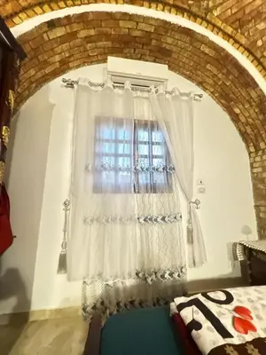 a bedroom with a window with white curtains at Salem & Renča Guest House in Luxor