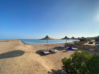 a beach with umbrellas and chairs and the ocean at الغردفه كازبلانكا ريزورت in Hurghada