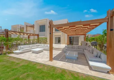 a patio with couches and a wooden pergola at Calm 3BR House in Shedwan Gouna BBQ, Pool & Lagoon in Hurghada